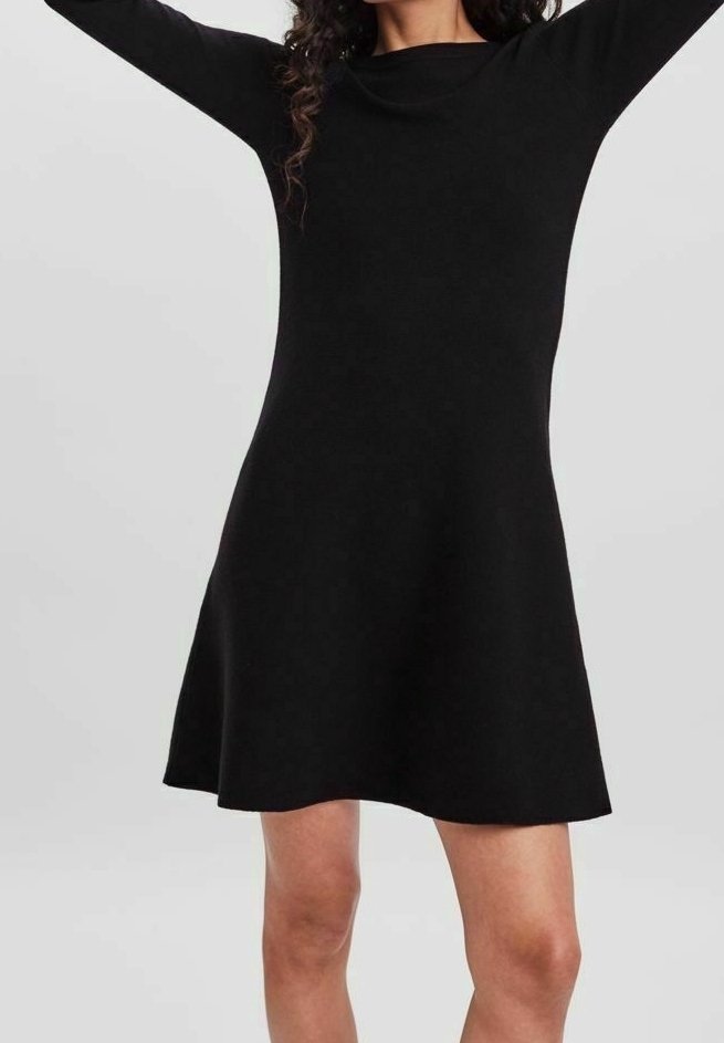 Robe noire trapèze en tissu lisse. Manches longues et encolure bateau. Longueur au-dessus du genou avec une légère évasement à l'ourlet.