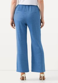 Ljust blå, vida byxor i ett smidigt material. Har ett elastiskt midjeband och en avslappnad passform. Bärs med sandaler med hög klack och remmar.