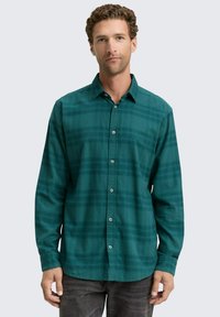 Groene geruite button-up shirt met lange mouwen, een kraag en een zak, gemaakt van een zachte stof met een soepele textuur.