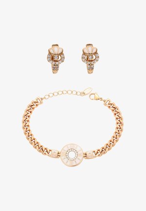 Guld kædearmbånd med rund hvid og rhinsten midterstykke med romertal, parret med matchende øreringe i guld, rhinsten og hvidt skaller.