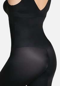 Zwarte bodysuit met een gladde, elastische textuur en een figuur-vriendelijke ontwerp. Heeft een brede band en gedeeltelijke transparantie aan de onderkant.