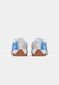 Blaue und graue Sportschuhe mit glatter Textur, Gummisohlen und klassischem Design, das ein weißes Nike-Logo an der Ferse aufweist.