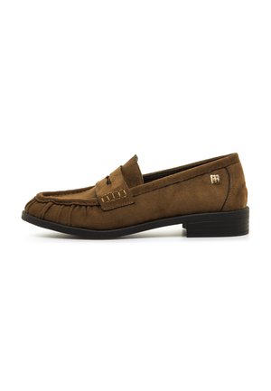 Mocassin en daim marron avec détails cousus, petit talon noir et petit logo métallique sur le côté, présenté de profil sur fond blanc.