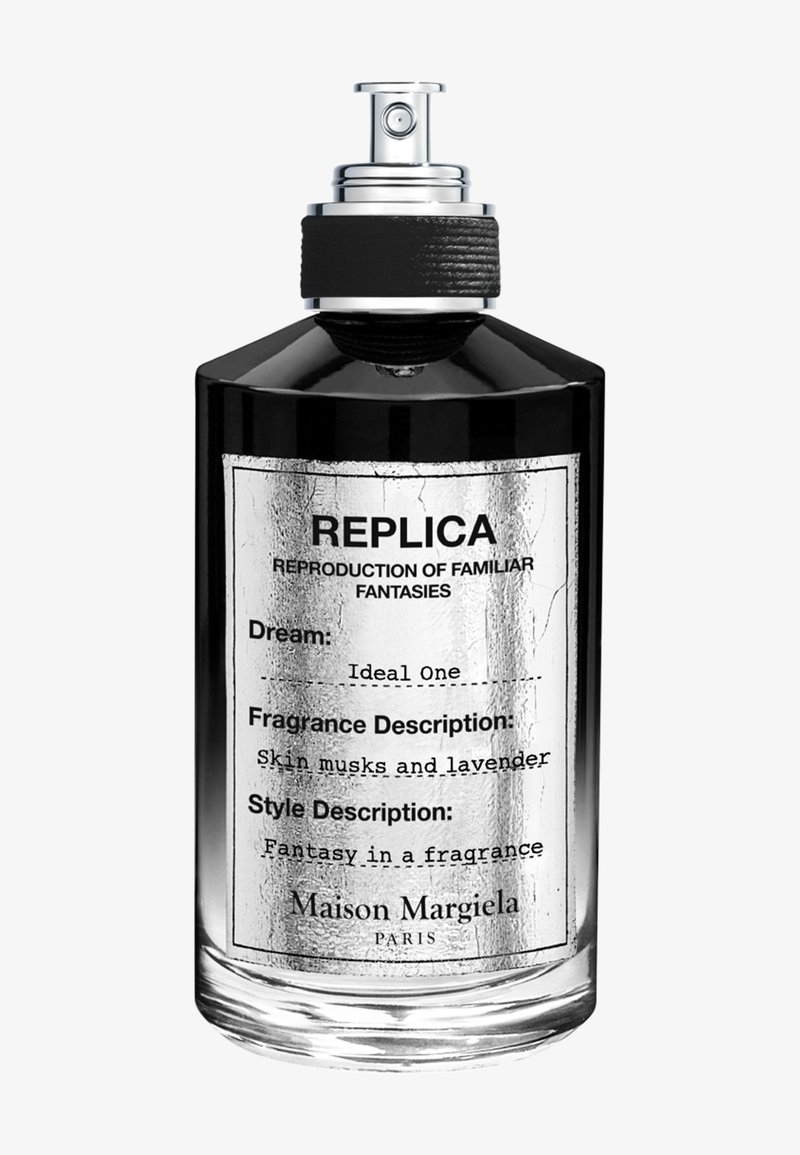 Bottiglia di profumo Maison Margiela Replica nera e argento con spray nero e etichetta che descrive la fragranza come muschi cutanei e lavanda.