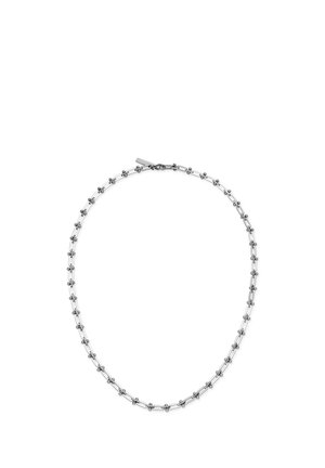 Collier chaîne en argent avec de petits maillons en forme de croix, espacés uniformément, et une étiquette de fermoir rectangulaire sur fond blanc.