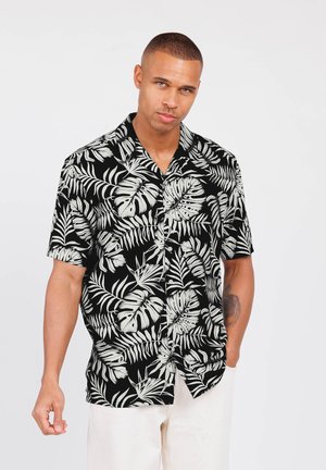Camisa de manga corta negra con patrón de hojas tropicales blancas; corte relajado; tejido ligero; cuello abierto; cierre de botones en el frente; diseño casual.