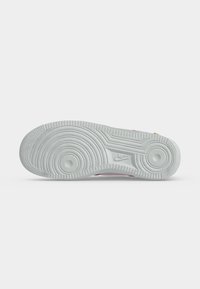 Σόλα λευκού αθλητικού παπουτσιού Nike με κυκλικά σχέδια πέλματος και το λογότυπο Nike κοντά στην καμάρα.