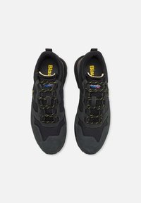 Scarpe sportive nere realizzate con una combinazione di materiali in suede e mesh; presentano accenti gialli, lacci testurizzati e una suola imbottita.