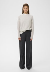 Light gray knit sweater with long sleeves, paired with dark gray wide-leg trousers. Features a smooth texture and a relaxed fit.