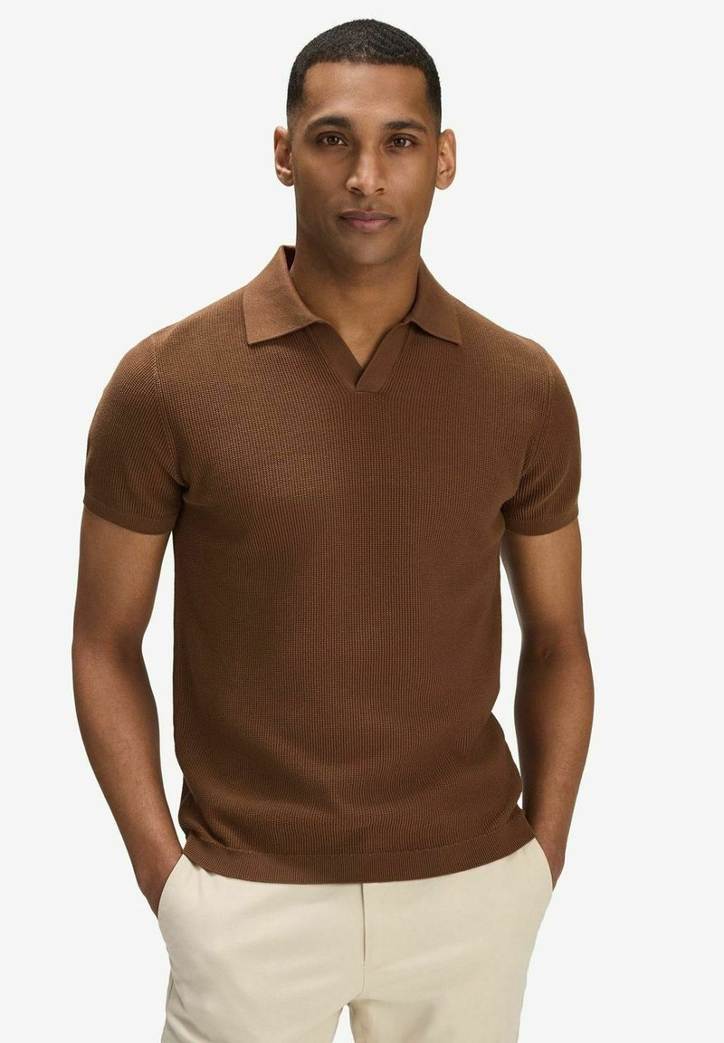 Brun randig kortärmad polo med V-hals och veckad krage. Slät textur, figurnära passform, kombinerad med ljusfärgade byxor.