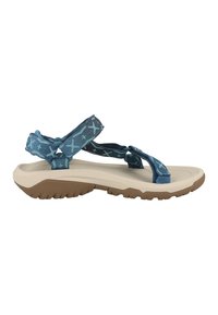 Blå mønstrede sandaler med en blød beige sål, der har justerbare remme og en struktureret gummisål for bedre greb.