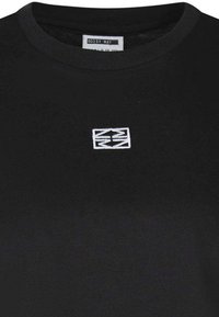 T-shirt en coton noir avec un col rond, arborant un petit logo brodé blanc au centre. Texture douce, coupe décontractée.