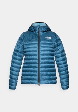 Blå boblejakke med kviltet design, hette og framside glidelås. Har The North Face-logoen på venstre bryst og en glatt, skinnende tekstur.