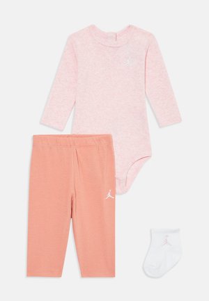 Beebi rõivaste komplekt, mis sisaldab pikka varrukaga roosa bodi, virsiku värvi legginsid Jordan'i logoga ning valgeid sokke roosa logoga.