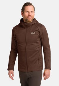 Bruine zip-up jas met een capuchon, voorzien van een logo op de borst, zijzakken en een textiel dat zorgt voor warmte en comfort.