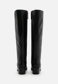 Black leather knee-high boots with a rounded toe, zipper closure at the back, and a low block heel. Smooth texture and sleek design.