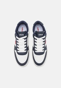 Granatowe i białe trampki z perforowaną teksturą, z białymi sznurówkami, subtelnym logo Levi's i zaokrąglonym noskiem.