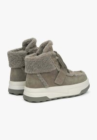Suède enkellaarsjes in gedempt groen, met een zachte fleece kraag, dikke witte zool en vetersluiting met textuuraccenten.