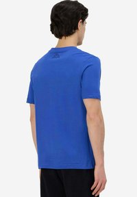 T-shirt in cotone blu a maniche corte con collo a giro, vestibilità rilassata e un piccolo logo nero sul retro in alto.