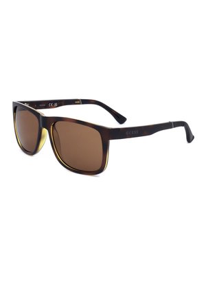 Occhiali da sole marrone tartaruga con lenti rettangolari marroni e logo "Guess" sulle aste.