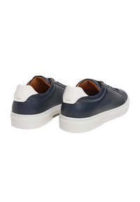Navyblå lädersneakers med en vit texturerad häl och krämfärgad sula. Har en rundad tå och snörning framtill. Insidan är brun.