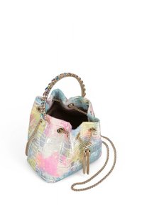 Bolso tipo bucket en material texturizado multicolor con un acabado brillante. Presenta herrajes dorados, correa de cadena y borlas decorativas.