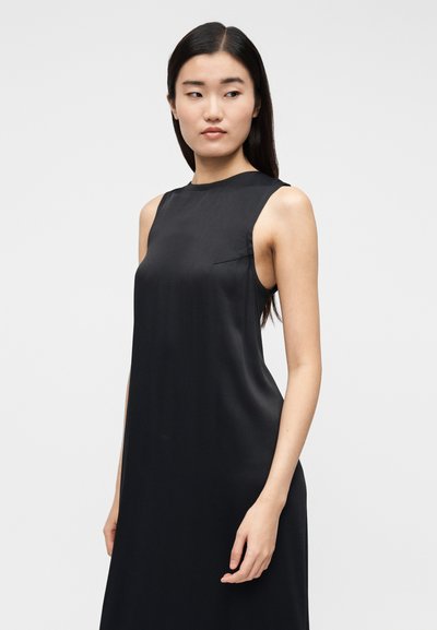 Vestido preto sem mangas, feito de tecido macio, com decote alto e design minimalista; possui um bolso lateral discreto.