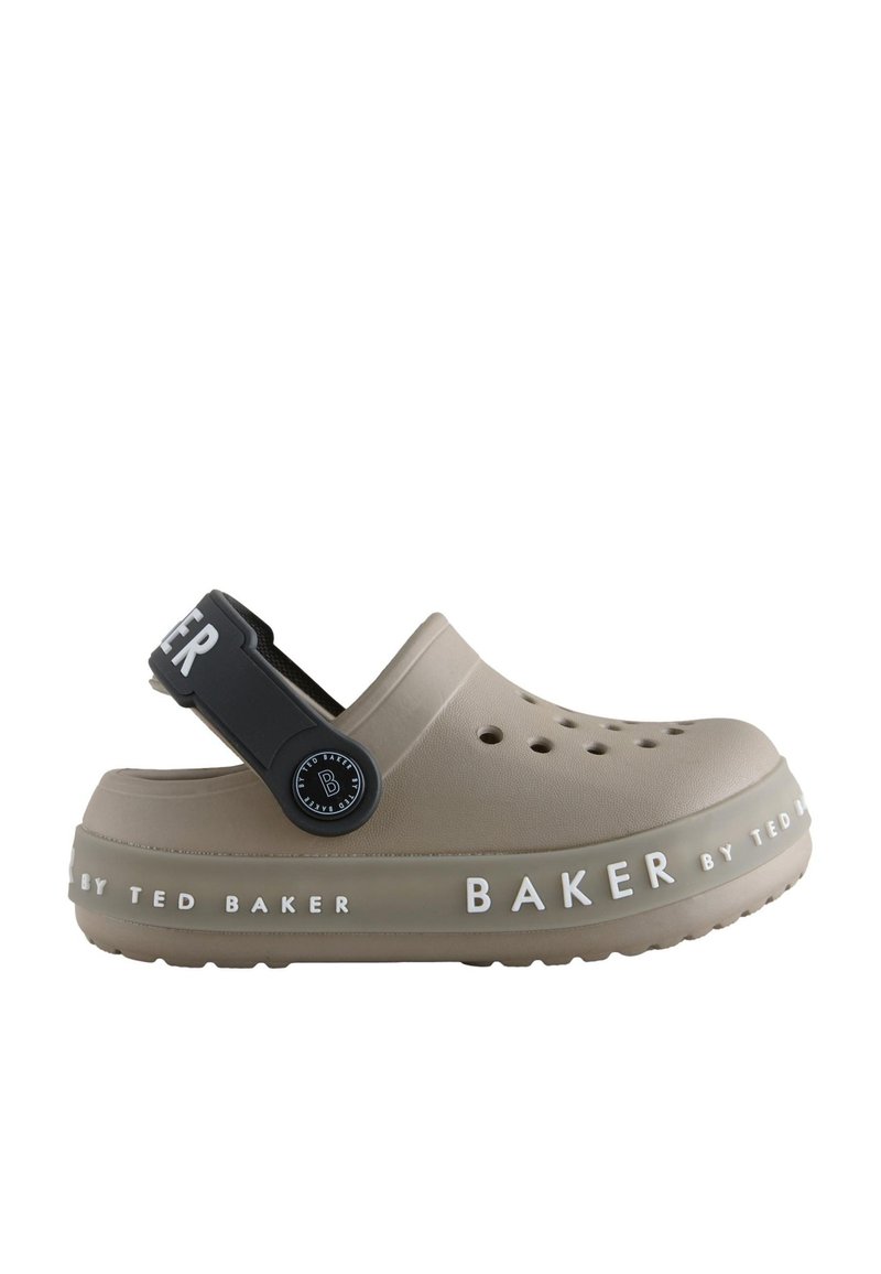 Beige rubber clog with a black adjustable strap and cutout ventilation. Features "BAKER by TED BAKER" branding in white along the sole.