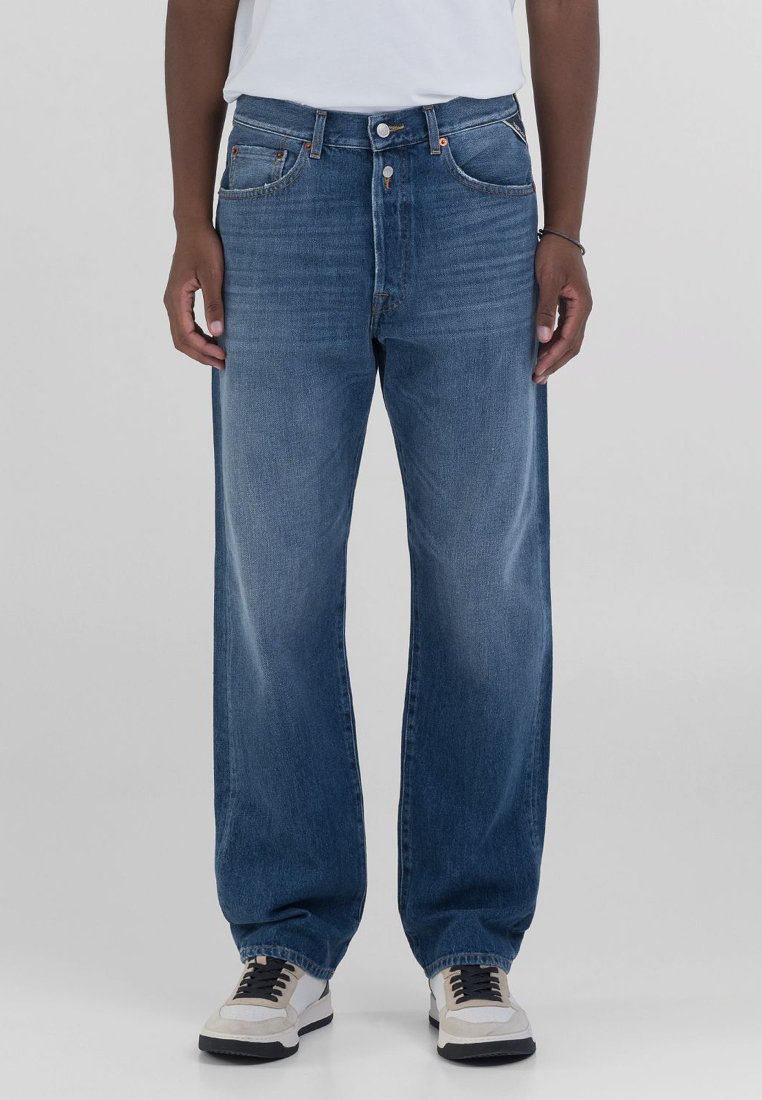 Lyseblå denim jeans med en afslappet pasform, der har lige ben, fem lommer og synlige stikninger. Stylet med hvide sneakers.