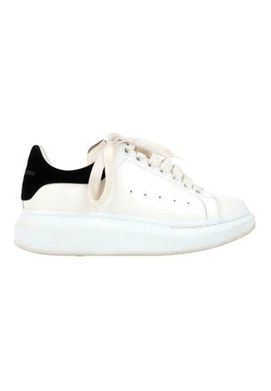 Biały skórzany sneaker z oversize'ową podeszwą, kremowymi sznurowadłami i czarną łatką na pięcie.