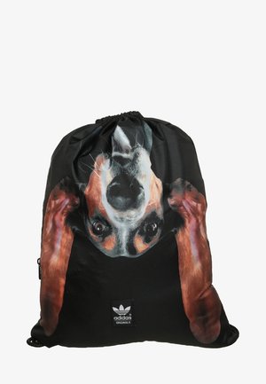 Czarna torba Adidas na sznurkach z dużą, odwróconą do góry nogami realistyczną twarzą psa z długimi brązowymi uszami i wyrazistymi oczami.
