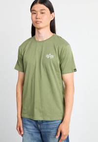 Olivengrøn bomulds-T-shirt med korte ærmer og rund halsudskæring. Har et lille hvidt trykt logo på venstre bryst og almindelig pasform.