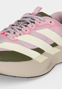 Chaussure de course légère avec tige rose, bout et accents vert olive, bandes blanches Adidas, et semelle beige rembourrée portant la mention "Lightstrike Pro."