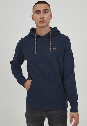Navy blue hoodie with a kangaroo pocket, drawstring hood featuring braided accents, and a small logo patch on the chest.