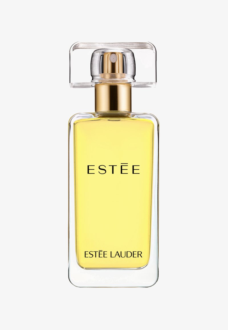 Botella de perfume de vidrio transparente con forma rectangular, líquido amarillo, acentos dorados y un tapón cuadrado. Incluye la marca "ESTÉE LAUDER" en la parte frontal.