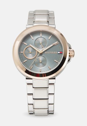 Montre argentée et rose gold avec bracelet en acier inoxydable, cadran rond, trois sous-cadrans, cadran texturé bleu et accents en rose gold.
