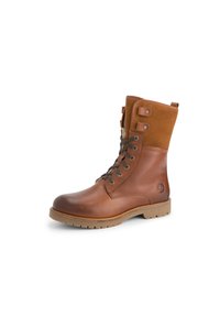 Bruine leren en suède veterschoenen tot de enkel met een robuuste zool en metalen veterogen op een witte achtergrond.