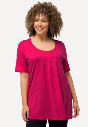T-shirt à manches courtes et décolleté en forme deU en tissu rose vif avec des plis sous le col, présentant une coupe décontractée et une texture douce.