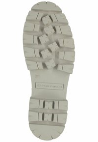 Semelle en caoutchouc blanche avec un motif texturé, présentant des reliefs profonds et des indentations en forme de croix. Les marques comprennent "TOM TAILOR" et la taille 37.