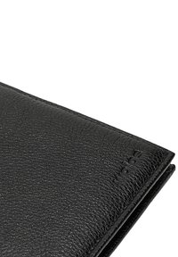 Zwarte leren portemonnee met een gestructureerde afwerking, voorzien van een gevouwen ontwerp en subtiele branding aan de zijkant. Compacte en gestroomlijnde vorm.