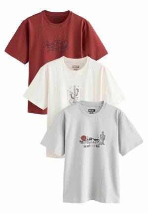 Kolme lyhythiupuisia crew neck T-paitaa ruosteenpunaisena, kermanvärisenä ja vaaleanharmaana, joissa on lännen teeman grafiikkaa ja tekstiä rinnassa.