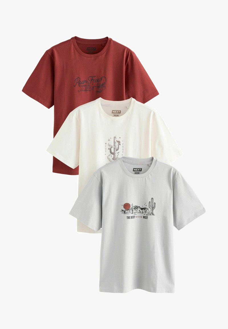 Trois T-shirts à manches courtes et col rond en rouge rouille, crème et gris clair, avec des graphiques et du texte sur le thème western sur la poitrine.