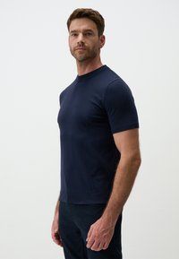 Granatowy t-shirt z krótkim rękawem i okrągłym dekoltem, wykonany z gładkiego materiału, o dopasowanym kroju i żebrowanym dekolcie, prezentowany na jednolitym tle.