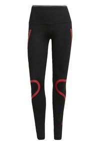 Czarne legginsy z wysokim stanem, z czerwonymi zakrzywionymi akcentami po bokach i okrągłym detalem z logo w okolicy kostki.