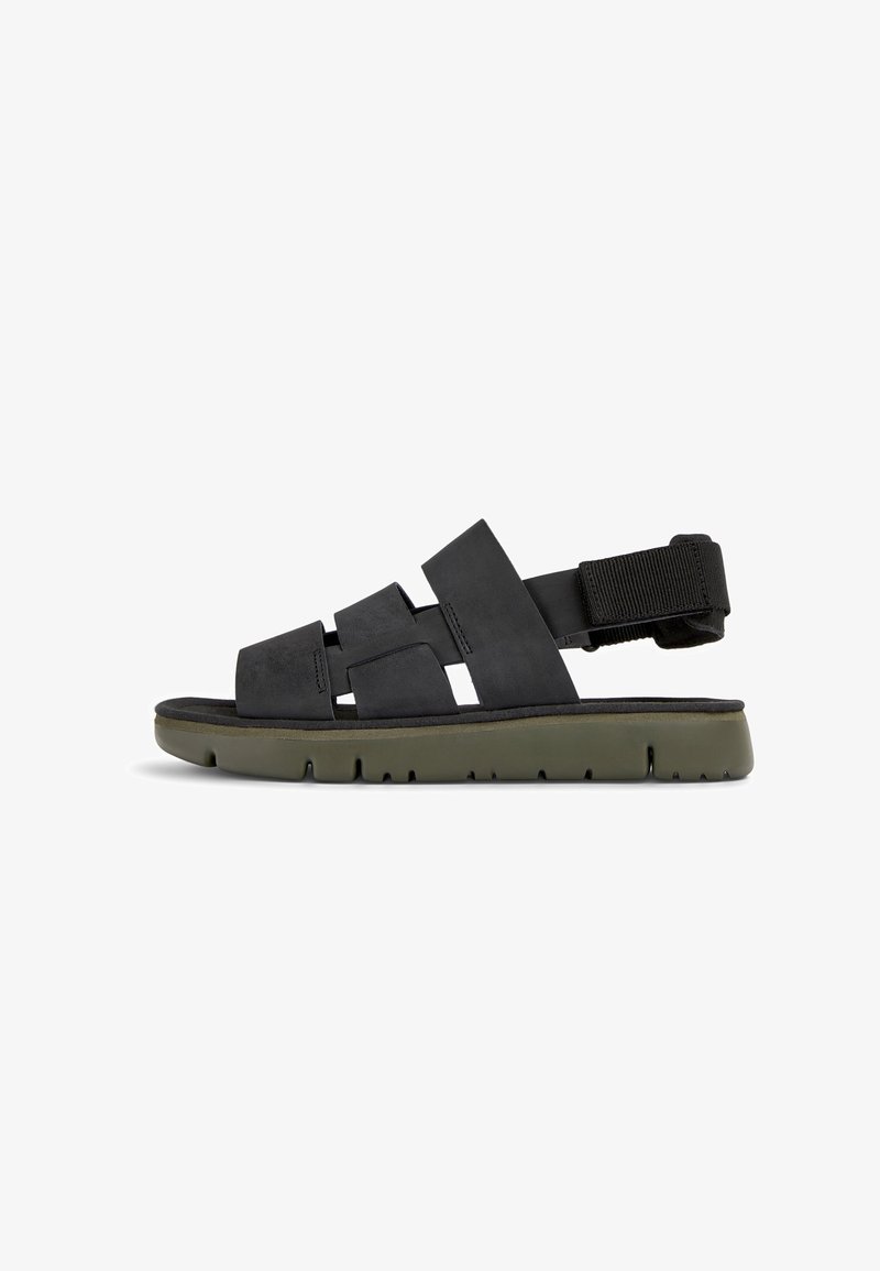 Black sandal with multiple wide straps across the upper, a cushioned footbed, and an olive green rubber sole. Adjustable ankle strap included.