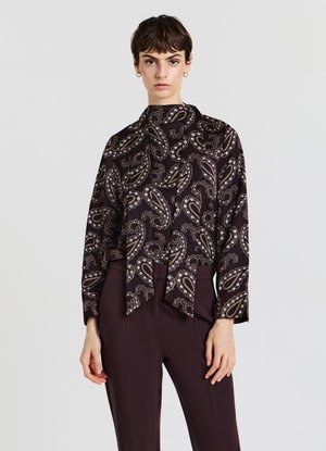 Dark paisley patterned blouse with a high neck, featuring a tie front. Made of smooth fabric, it has long sleeves and a relaxed fit.