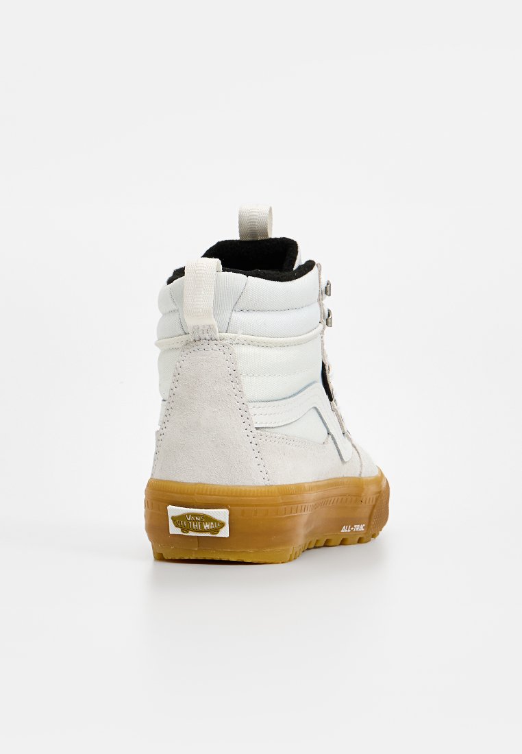 High-Top Sneaker aus weißem Leder und grauem Wildleder, ausgestattet mit einer Gummisohle, silbernen Ösen und einem Schlaufenetikett an der Rückseite für einfaches Anziehen.