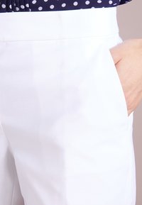 Vita skräddarsydda byxor med en slät textur, med sidofickor och ett snyggt midjeband för en slimmad passform.
