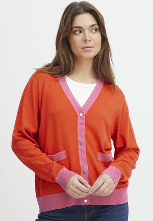 Oranger Cardigan mit pinken gerippten Akzenten an den Ärmelbündchen, dem Saum und den Taschen. Verfügt über einen V-Ausschnitt und eine Knopfverschluss, aus leichtem Strickmaterial.