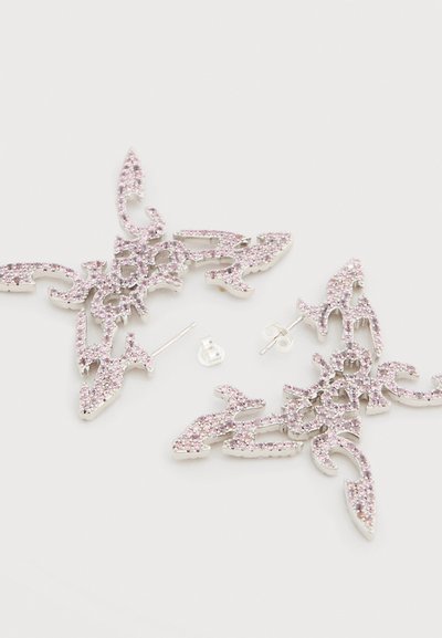 Σκουλαρίκια με ροζ κρύσταλλα σε διακοσμητικό ασημένιο σχέδιο. Διαθέτουν περίπλοκα σχήματα και υφές, με καρφί πίσω. Λάμποντες πινελιές σε όλο το κόσμημα.
